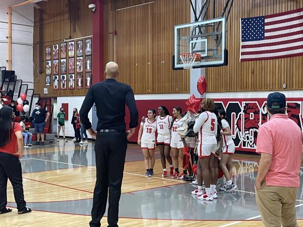 The Central girls varsity basketball team celebrates senior night during halftime as head coach Loren Woods looks on. (Photo by Dexter Zinman)